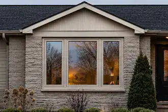 Side-hinged casement window open outward for ventilation on a residential home.
