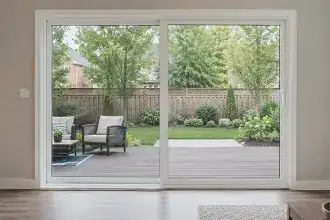 Large patio doors connecting a bright home interior to an outdoor backyard space.
